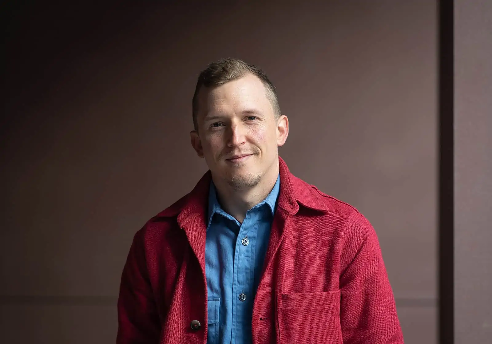 WooCommerce strategist, Piers tincknell, faces camera wearing red jacket and blue shirt