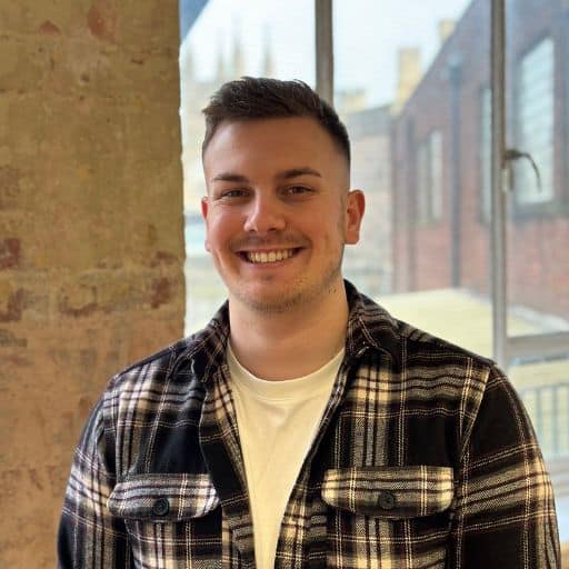 Jack looking at camera in front of exposed brick and window