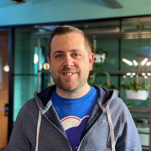 Matt looking at camera in front of glass meeting room