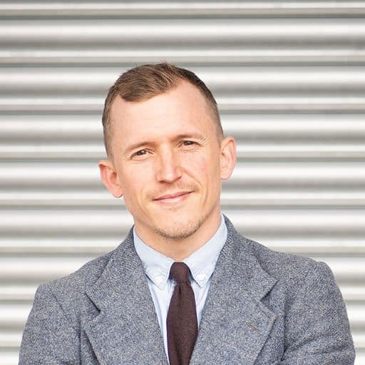 Piers looking at camera in front of an industrial backdrop