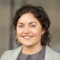 Headshot of woman with curly dark hair in smart casual attire