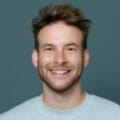 Headshot of man wearing jumper indoors