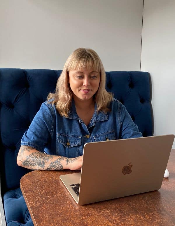 Katie, Sales Strategist, sat in office booth working on laptop