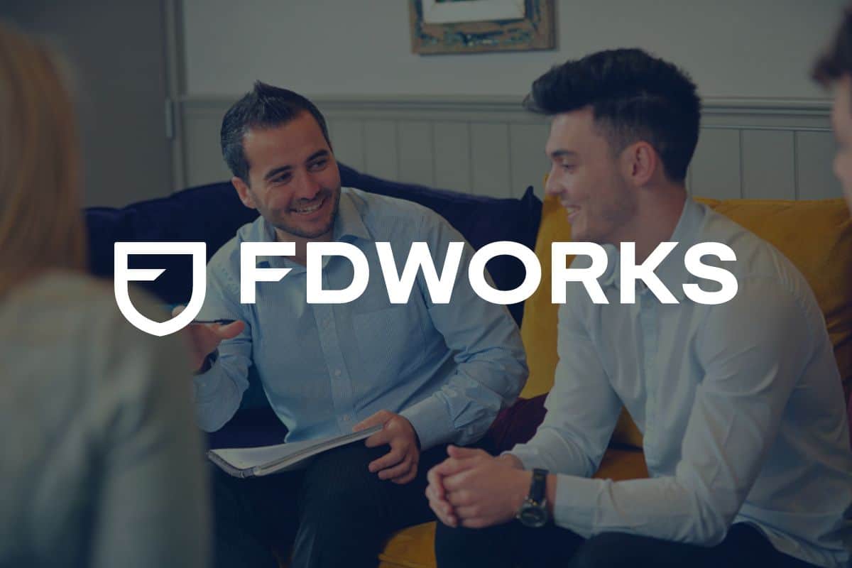 FD Works logo i front of colleagues talking in a meeting