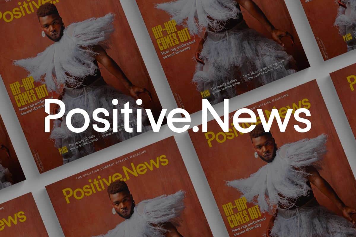 Positive News logo in front of copies of the magazine