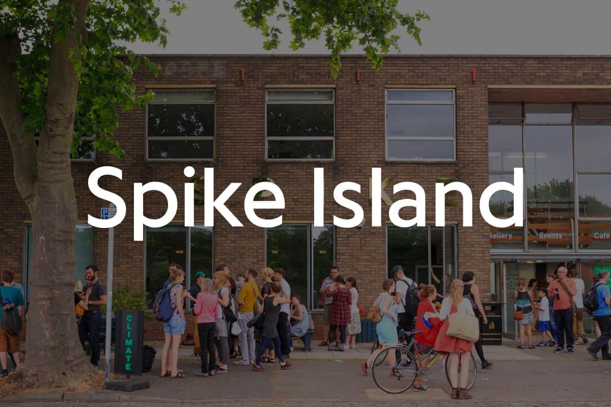 Spike Island logo in front of image of the outside of the building with people gathered around