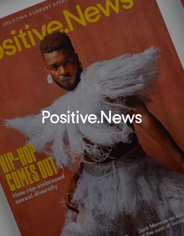 Positive News logo in front of copies of the magazine