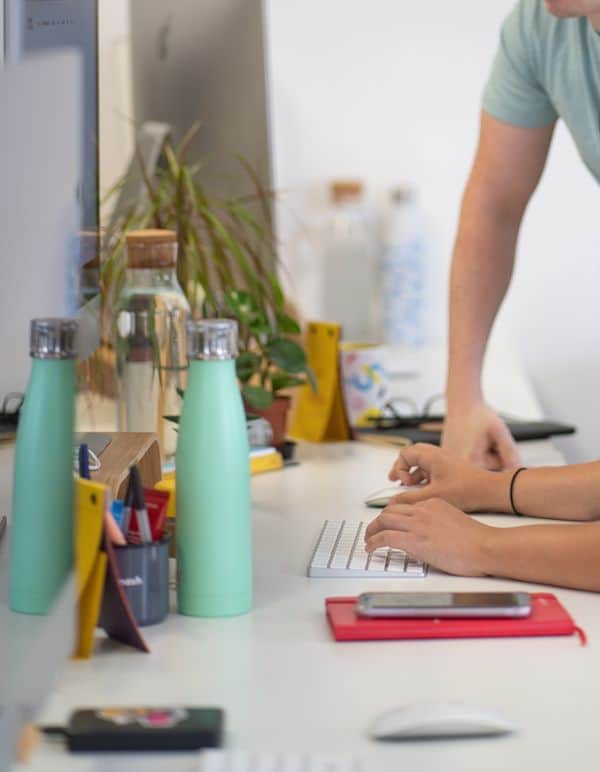 Colleagues working in a desk and looking at a computer screen together