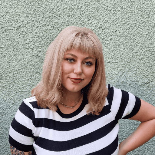 Katie wearing striped top in front of wall