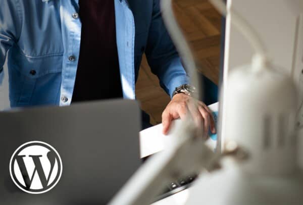 Image of Atomic Smash WordPress agency in Bristol showing developer working on laptop and computer screen plus WordPress logo