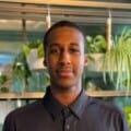 Bristol Creative Industries intern, Ahmed, stood in creative office space with plants hanging in the background