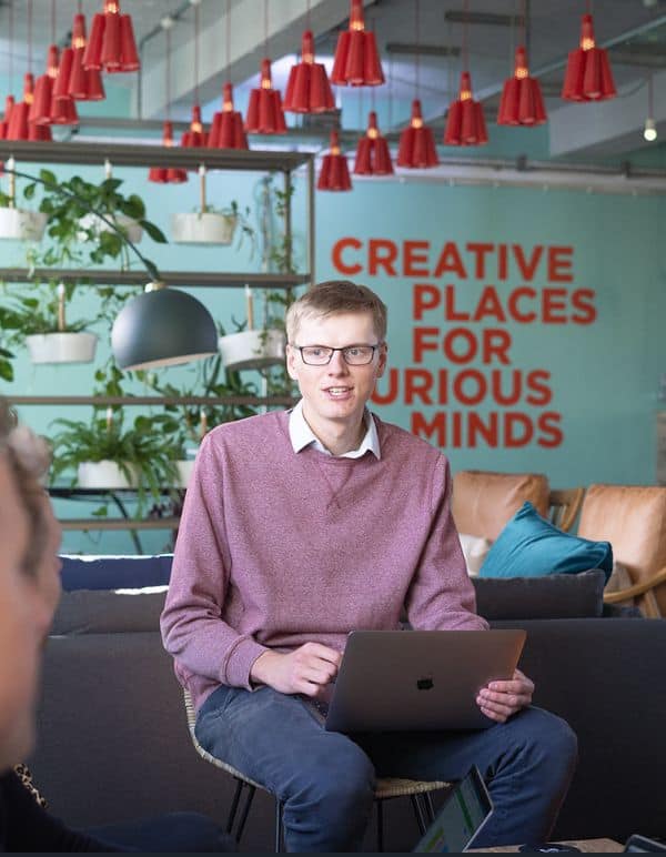 Jamie sat with laptop in creative workspace