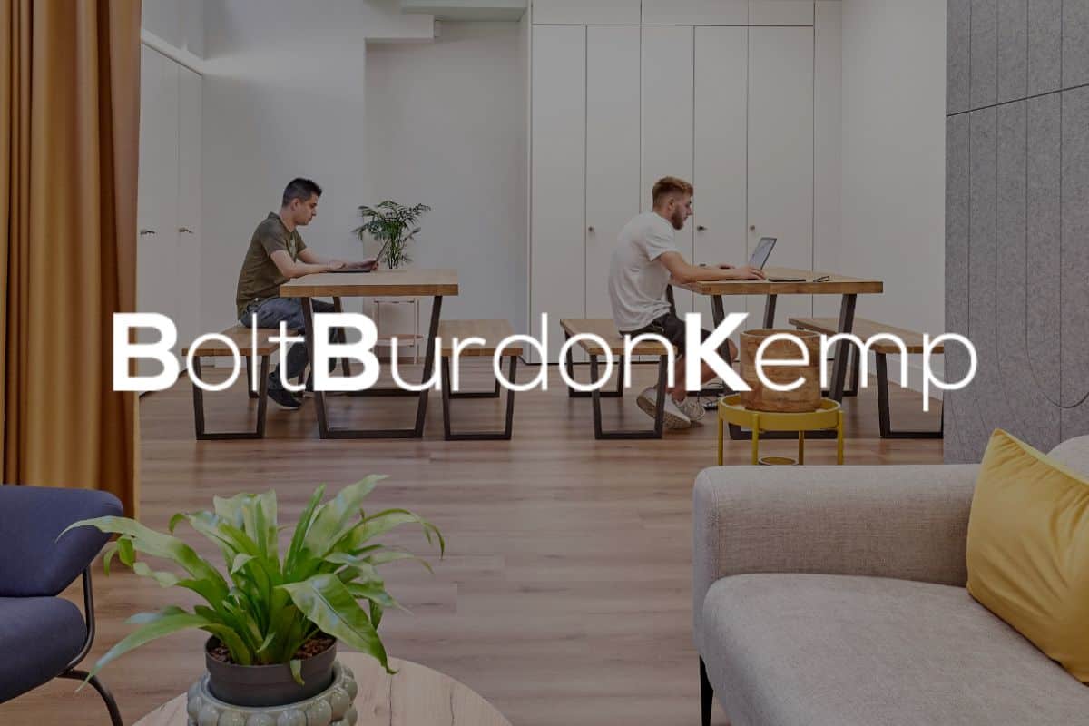 Team members working in office at Bolt Burdon Kemp, plus logo overlayed on top