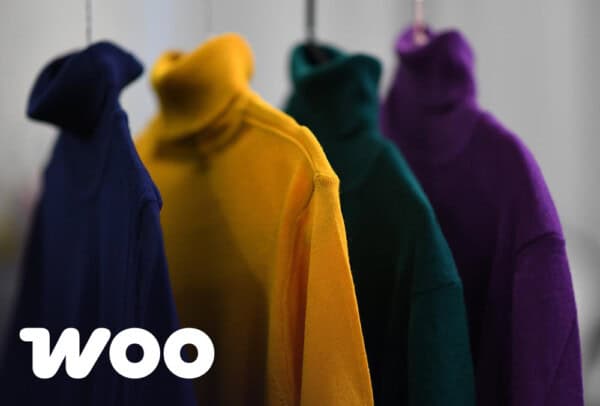 Clothes hung up in the background with WooCommerce logo in the foreground corner, accompanying a page about Bristol WooCommerce agency, Atomic Smash